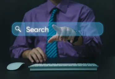 This is a man who is clicking on a search button with one hand while the other hand points to a keyword. He represents a special PPC agency in delhi